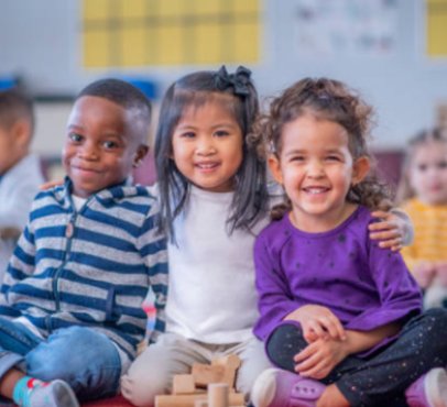 three kids sitting next to each other and smiling